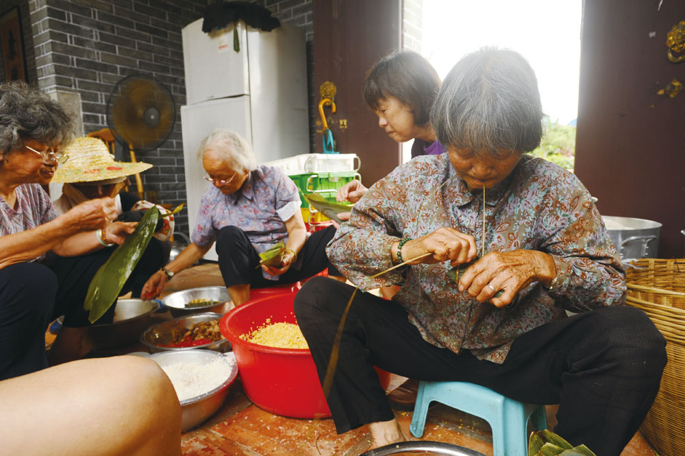 一眾文婆婆、文嬸嬸正在落力地包粽，將文化和好味道一起傳承下去。