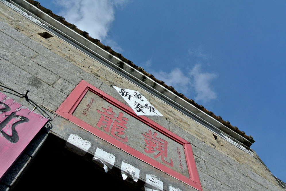 新圍又名覲龍圍，門樓石額刻有「覲龍」 二字，為清朝乾隆甲子（1744年）年所刻。而青磚搭建圍牆，保留傳統圍村格局。