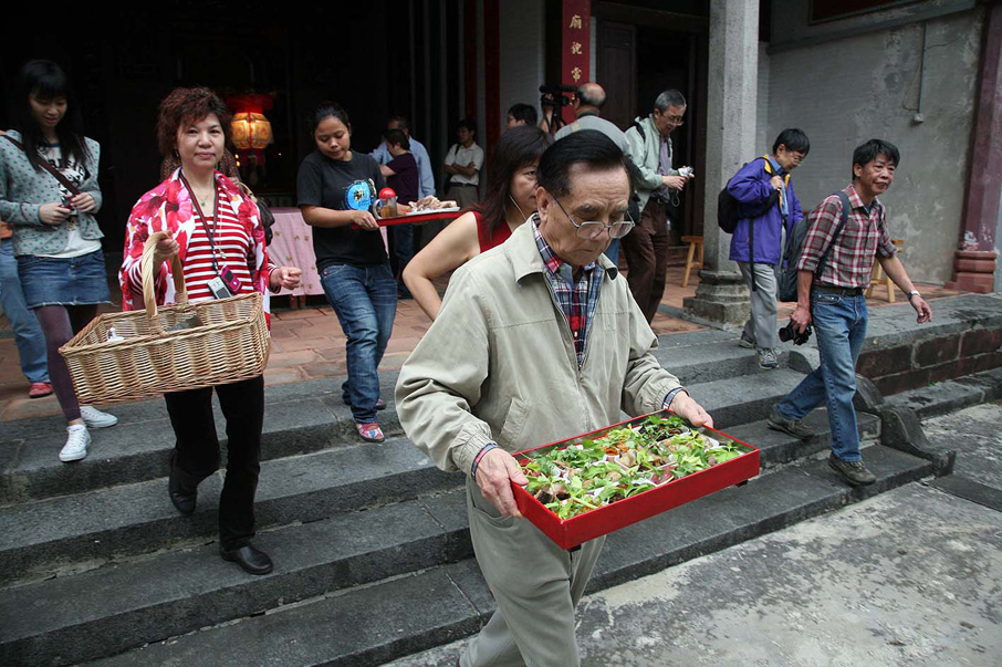 添丁家庭帶備煮 好的菜餚到祠堂供奉祖先。
