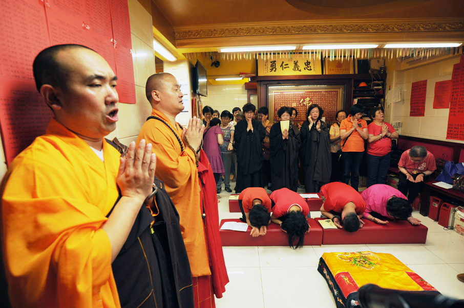 關帝誕，狹小的住宅內神壇佈滿善眾和僧人唸經。