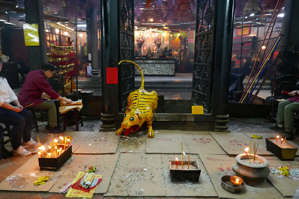 市民在路旁燃點香燭，祭白虎和打小人。